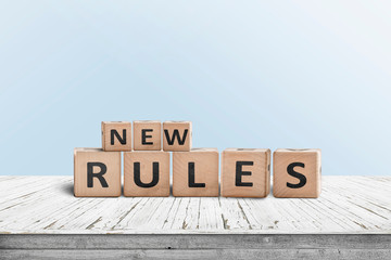 New rules sign made of wood on a desk