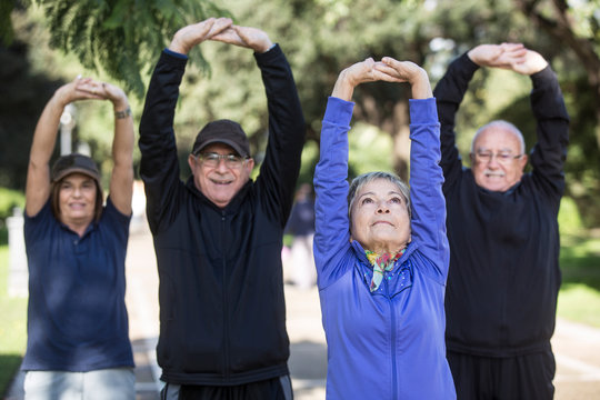Anziani signori fanno attivit&agrave; sportiva in mezzo ad un parco 
