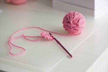 Pink yarn ball with woolen thread on white background