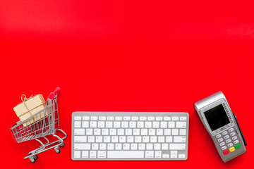 making purchase online with keyboard, card machine and mini trolley on office desk background top...