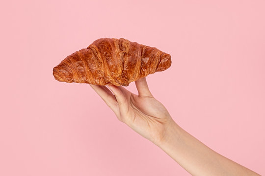 Woman presenting sweet croissant bun 