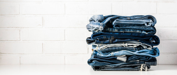 A stack of old jeans on a light background