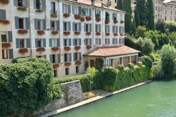 Fototapeta premium Red flowers on facade in Bassano del Grappa, Italy