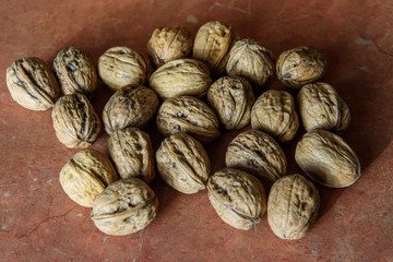 Dry walnuts (Juglans) in their shells. It contains a lot of manganese, magnesium, phosphorus and Vitamin B6. Walnuts contains also other minerals and vitamins.