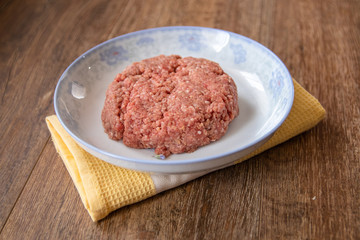 Fototapeta na wymiar Fresh raw minced meat on plate on a wooden table
