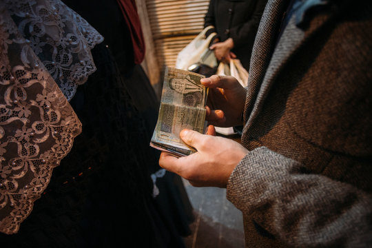 Close-up of Traveler Holding Jordanian Dinar Banknotes while Waiting in Line