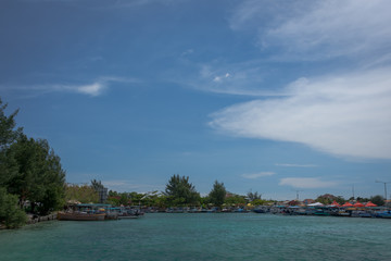 Fototapeta na wymiar The traditional port on Harapan Island, Indonesia with fishing boats that are waiting and ready to bring tourists to explore the beauty of the island