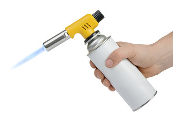 Hand holding gas can with manual torch burner (blowtorch) with blue flame isolated on white...