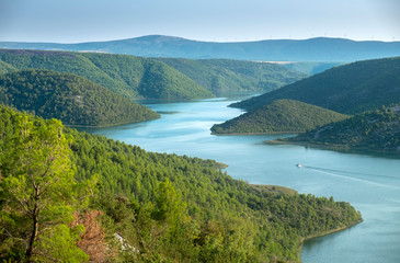 Amazing aerial view of boat on Krka river and Visovac Lake at sunset time. Krka National Park, Croatia