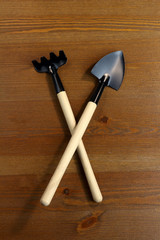 Shovel and rake for garden work  with wooden handle on wooden background