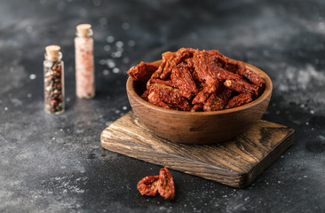 Sun dried tomatoes with fresh herbs and spices, sea salt in olive oil in a glass jar. Top view. Print for kitchen