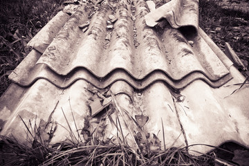 Illegal asbestos dumping - Roofing asbestos panels illegally abandoned in nature - toned image