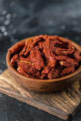 Sun dried tomatoes with fresh herbs and spices, sea salt in olive oil in a glass jar. Top view. Print for kitchen