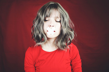 Young woman with a cross covering her mouth