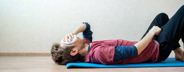 young sport man laying on the floor on yoga mat after hard practice f