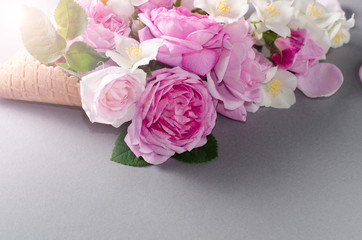 Fresh spring roses in waffle cone. Beautiful romantic background in flat lay style.