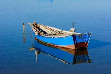 Fototapeta premium Old fishing boats with bright colors at dawn on the lake.