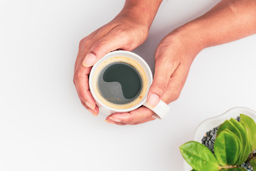 girl's hands holding coffee cup with plant flat lay top view
