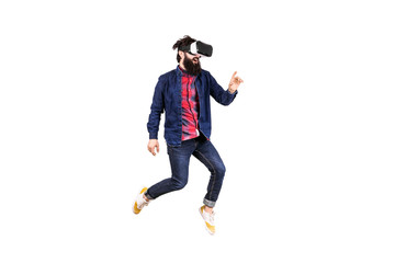 full length portrait of young bearded hipster man in virtual reality glasses, jumping and touching...