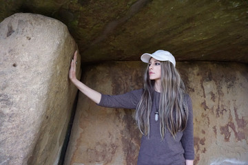 Girl touching ancient megalithic stone dolmen