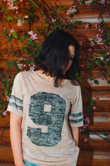 Brunette girl stands near a flowering tree. A warm Sunny day, blooming Apple tree.