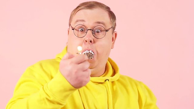 Stressed corpulent man trying to smoke a whole pile of cigarettes simultaneously, slow motion