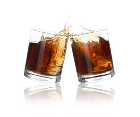 Glasses of expensive whiskey clinking together and splashing on white background