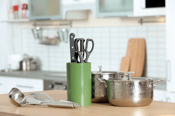 Set of clean cookware and utensils on table in kitchen. Space for text