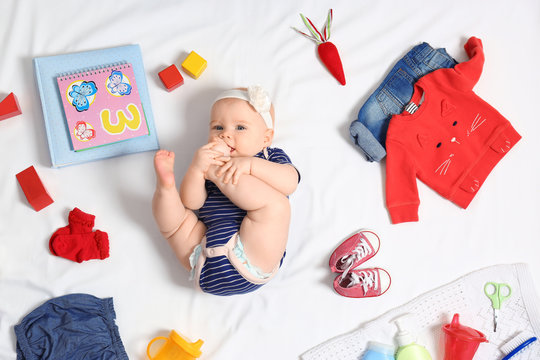 Cute little baby with clothing and accessories on white background, top view