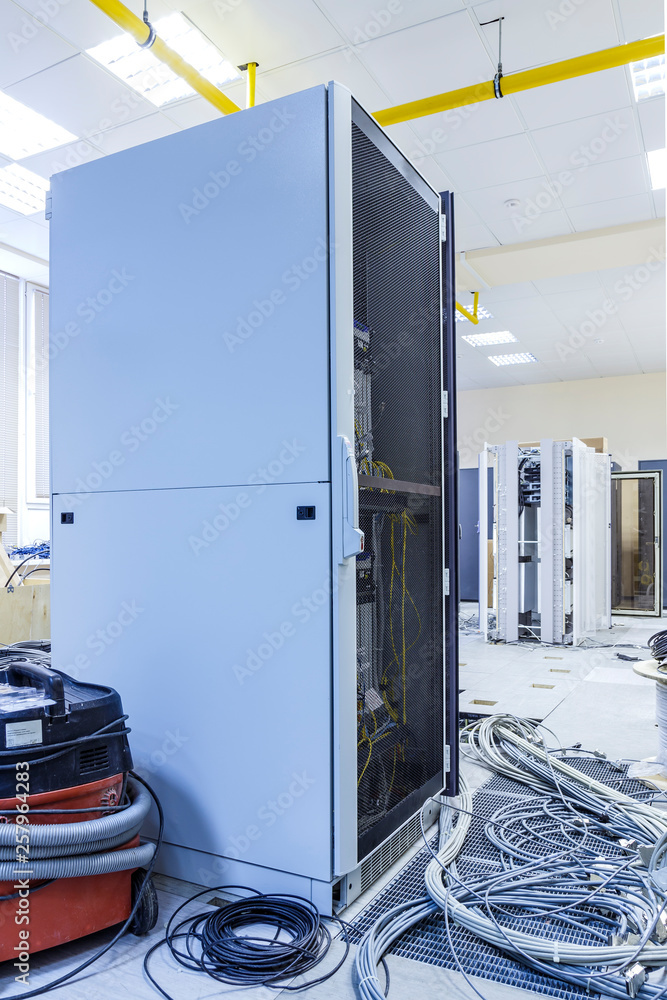 Aufkleber process of installation and cabling in a modern data center. server rack with skeins of cables next 