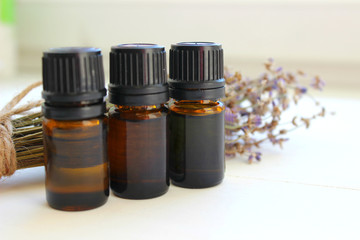 Aromatherapy. Jars of essential oils and a bouquet of lavender flowers on a white background. Copy space.