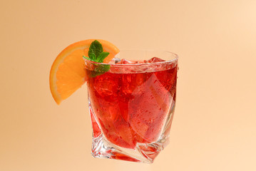 Red fresh drink with ice, grapefruit and mint on an beige background. Space for text or design.