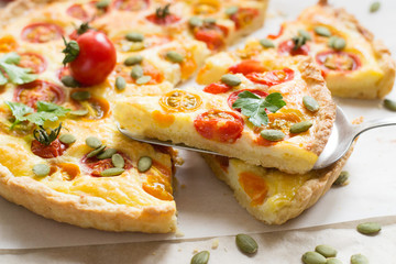 Tomato tart with pumpkin seeds on wooden table