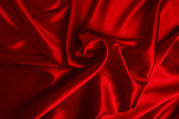 Red silk or satin luxury fabric texture can use as abstract background. Top view.