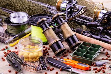 fishing tackle on a wooden table. toned image 