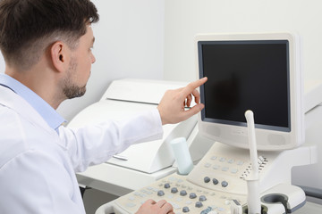 Fototapeta na wymiar Professional sonographer using modern ultrasound machine in clinic