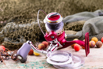 fishing tackle on a wooden table. toned image 