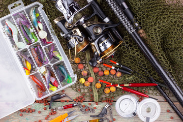 fishing tackle on a wooden table. toned image 