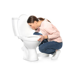 Young woman suffering from nausea near toilet bowl isolated on white
