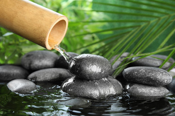 Traditional bamboo fountain with zen stones. Space for text