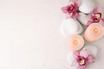 Abwaschbare Fototapete Zen Flache Komposition mit Zen-Steinen, Kerzen und Blumen auf Holzhintergrund. Platz für Text