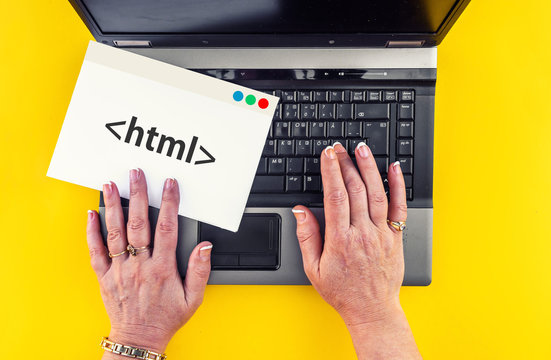 Hyper Text Markup Language. woman hands on laptop and html tag on paper sheet