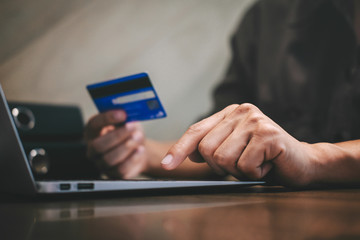 Businessman holding credit card and typing on laptop for online shopping and payment makes a purchase on the Internet, Online payment, Business financial and technology