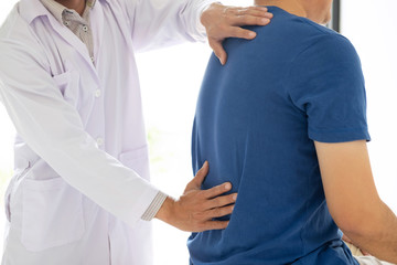 Doctor physiotherapist treating lower back pain patient after treatment