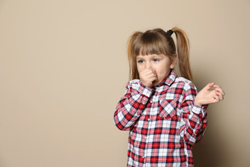 Cute little girl coughing against color background. Space for text