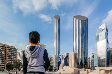 Young kid looking at Abu Dhabi city - Architecture and famous skyscrapers of Abu Dhabi skyline with beautiful clouds, World Trade Center, UAE