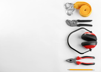 Flat lay composition with construction tools and safety equipment on white background. Space for text