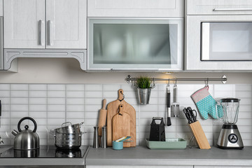 Kitchen interior with clean cookware, appliances and dish cabinet
