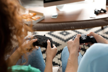 Young couple playing video games at home, closeup