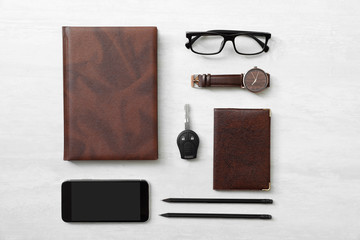 Naklejka premium Flat lay composition with male accessories and car key on light background. Space for text